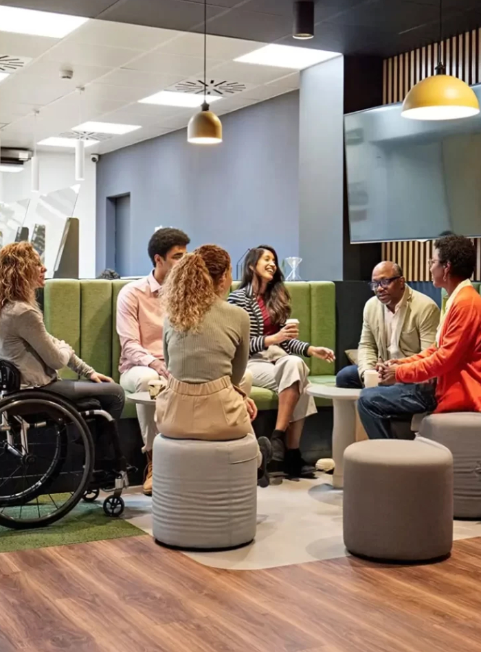 A supportive male caregiver smiling next to a woman in a wheelchair, representing a dedicated NDIS Provider in Cannington.